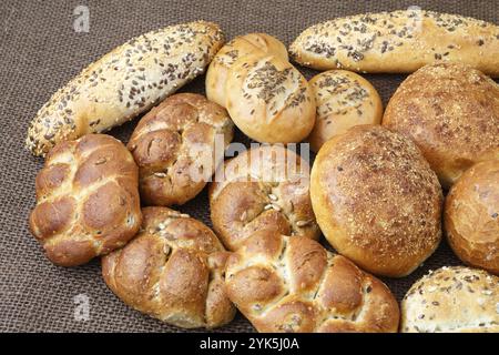 Verschiedene Arten von Vollkorn Brot und Brötchen auf braunem Hintergrund Stockfoto