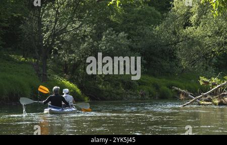 Familien-Kajakausflug für Seigneur und Senora. Ein älteres Ehepaar rudert ein Boot auf dem Fluss, eine Wasserwanderung, ein Sommerabenteuer. Altersbedingte Sportarten Stockfoto