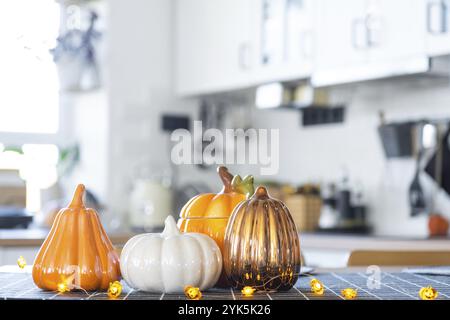 Dekor der weißen klassischen Küche mit Kürbissen für Halloween und Ernte. Herbststimmung im Innenraum, moderner Loft-Stil Stockfoto