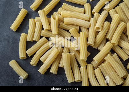 Rohe italienische Penne rigate Pasta isoliert auf schwarzem Hintergrund Stockfoto