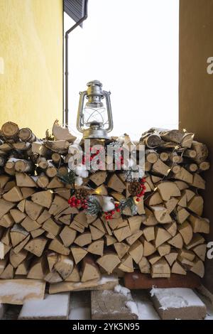 Das Feuerholz auf der verschneiten Veranda des Hauses wird für den Winter geerntet. Heizen von Wohnungen mit einem Ofenkamin, um Strom und Gas in einem C zu sparen Stockfoto