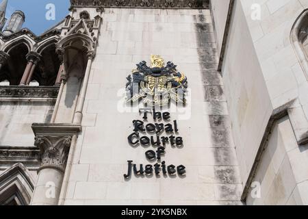 Nahaufnahme des Wortlauts und Wappens / Logos an der Seite des Royal Courts of Justice, einem gotischen Gebäude am Strand, London, Großbritannien Stockfoto