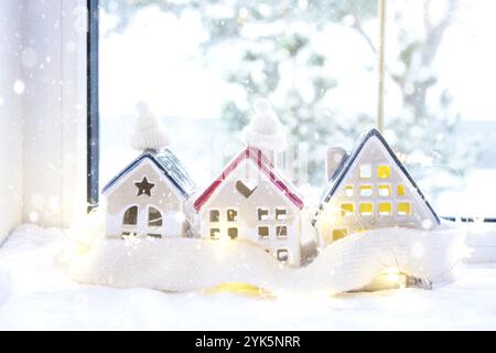 Schlüssel zum Haus mit Schlüsselanhänger auf einem gemütlichen Zuhause mit Weihnachtsdekor. Ein Geschenk für Neujahr, Weihnachten. Gebäude, Entwurf, Projekt, Umzug in ein neues Haus Stockfoto