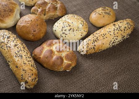 Verschiedene Arten von Vollkorn Brot und Brötchen auf braunem Hintergrund Stockfoto