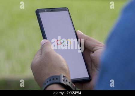 Person, die ein Mobiltelefon mit dem Logo des indischen Technologieunternehmens Zoho Corporation auf dem Telefonbildschirm hält – Dhaka, Bangladesch 29. September 2024 Stockfoto