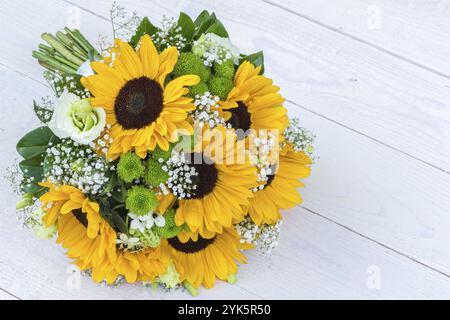 Hochzeitsstrauß aus Sonnenblumen auf hölzernem Hintergrund. Draufsicht mit Kopierbereich Stockfoto