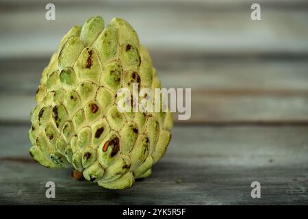 Puddingäpfel oder Zuckeräpfel oder Annona squamosa isoliert auf hölzernem Hintergrund. Horizontale Aufnahme. Kopierbereich für Text Stockfoto