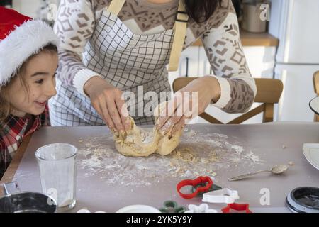 Mom und Tochter in der weißen Küche bereiten Kekse für Weihnachten und Neujahr zu. Familientag, Vorbereitung auf den Urlaub, lernen Sie Delicio zu kochen Stockfoto