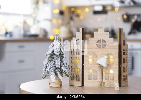 Schlüssel und winziges Haus von kleiner Größe auf gemütlichem Haus mit Weihnachtsdekor auf dem Tisch der festlichen weißen Küche. Geschenk für Neujahr. Versicherung, zieht in eine neue Ho Stockfoto