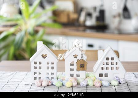 Schlüssel zum Haus eines gemütlichen Hauses mit Osterdekor mit Hase und Eiern auf dem Tisch der Küche. Gebäude, Entwurf, Projekt, Umzug in ein neues Haus, Hypothek, Versicherung Stockfoto