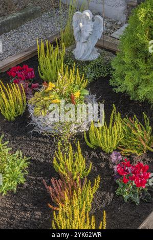 Grab mit Blumenschmuck, Heidekraut, Heidekraut (Calluna vulgaris) und betender Engel, Dietmannsried, Allgaeu, Bayern, Deutschland, Europa Stockfoto