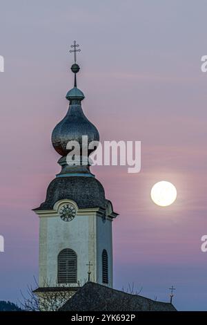 Kirchturm von Haus im Ennstal mit Vollmond und Sonnenuntergang im Hintergrund Haus im Ennstal City Steiermark Österreich Stockfoto