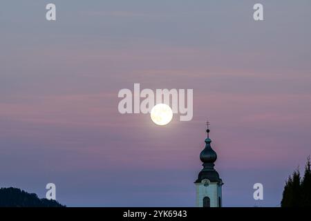 Kirchturm von Haus im Ennstal mit Vollmond und Sonnenuntergang im Hintergrund Haus im Ennstal City Steiermark Österreich Stockfoto