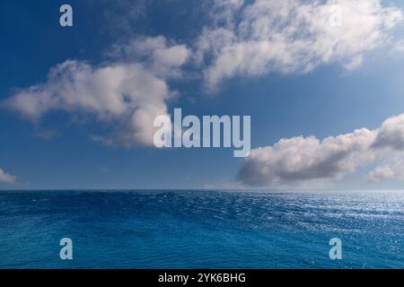 Meereslandschaft mit blauem Meer über blauem Himmel mit weißen Wolken mit Sonnenreflexionen. Panoramablick über das Mittelmeer von Korsika aus gesehen, Frankreich Stockfoto