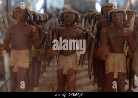 Diese 4.000 Jahre alten Holzmodelle ägyptischer Speermänner mit großen Schilden sind in einer Galerie des neu eröffneten Großen Ägyptischen Museums ausgestellt. Stockfoto