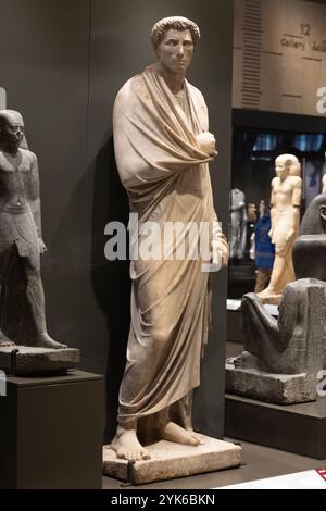 In der Galerie 12 des neu eröffneten Großen Ägyptischen Museums steht eine Marmorstatue eines Mannes, der griechische Kleidung aus der ägyptischen Römerzeit trägt. Stockfoto