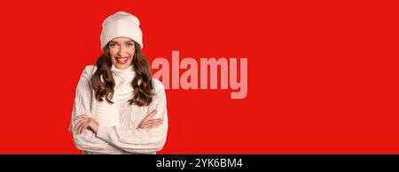 Junge Frau im Winter Strickpullover posiert auf rotem Hintergrund Stockfoto