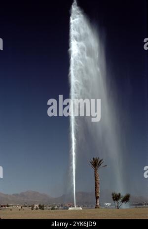 Fountain Hills, Arizona. USA 1975. Fountain Hills hat den vierthöchsten Brunnen der Welt und den zweithöchsten in den Vereinigten Staaten. Sie wurde 1970 in Zürich von Robert P. McCulloch erbaut. Das Jahr davor. Der Brunnen sprüht Wasser für ca. 15 Minuten stündlich zwischen 9:00 und 21:00 Uhr. Die Wolke erhebt sich aus einer Betonskulptur mit Seerosen in der Mitte eines großen künstlichen Sees. Der Brunnen, angetrieben von drei Turbinenpumpen mit 600 PS (450 kW), sprüht Wasser mit einer Geschwindigkeit von 7.000 US Gallonen (26.000 l; 5.800 imp gal) pro Minute durch eine 460-mm-Düse. Stockfoto