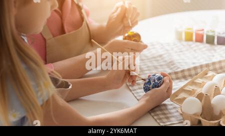 Kleines Kind mit Oma, das Eier für Ostern malt, Nahaufnahme Stockfoto