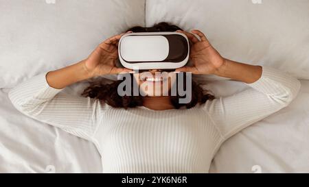 Afroamerikanische Frau Trägt Virtual Reality Brille Im Bett Stockfoto