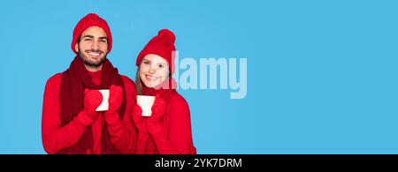 Glückliches Junges Paar Trägt Winterhandschuhe, Hält Tassen Mit Tee Und Lächelnd Stockfoto