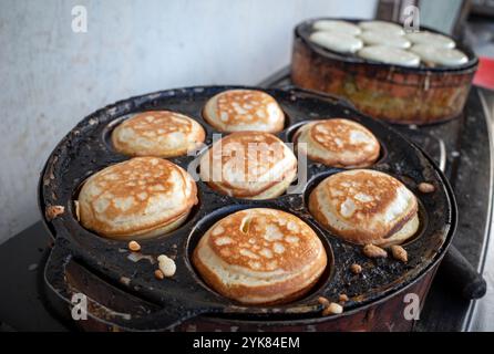 Der Prozess der Zubereitung von Kue Apem, einem traditionellen indonesischen Kuchen auf dem Street Food Markt, in Yogyakarta, Indonesien. Stockfoto