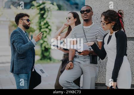 Vier junge Fachkräfte, die ein Business Meeting im Freien führen Stockfoto