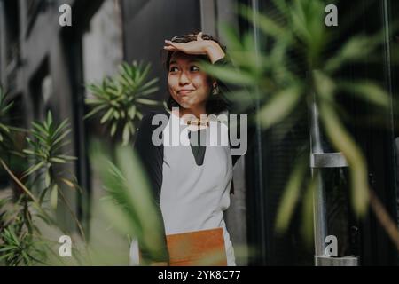 Eine junge Frau, die einen sonnigen Tag vor dem Büro genießt Stockfoto