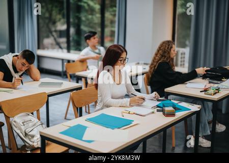 Konzentrierte Schüler, die in modernen Klassenzimmern mit großen Fenstern studieren Stockfoto