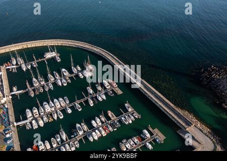 Luftdrohne für Segelboote, die an Piers im Hafen von Cascais in Portugal vor Anker gehen. Von oben Schuss von Booten im Hafen in der Stadt während sonniger Tage. Stockfoto