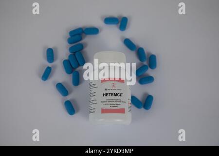 Eine Flasche Hetemcit, eine Präexpositionsprophylaxe oder Präparate zur HIV-Prävention, mit blauen Tabletten um sie herum. Weißer Hintergrund. Stockfoto