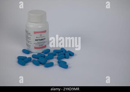 Eine Flasche Hetemcit, ein Präexpositions-Prophylaxemedikament zur HIV-Prophylaxe. Blaue Pillen im Vordergrund. Weißer Hintergrund. Stockfoto