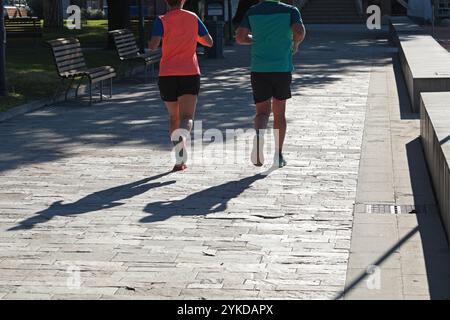 Leute, die im Park in der Nähe von Ligurien laufen, Schwester Levante, Italien. Silhouette und Sonnenlicht. Natur und Sport. Sonniger Herbsttag. Umweltfreundlich Stockfoto