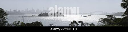Sydney, Australien, Panoramablick auf die Sydney Harbour Bridge & Opera House unter leichtem Nebel, die Skyline des CBD in Silhouette Sonnenlicht auf dem Wasser Stockfoto