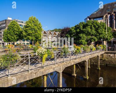 Quimper, Frankreich - 28. Juli 2024: Ein malerischer Blick auf eine Brücke in Quimper, Bretagne, geschmückt mit bunten Blumen über einem ruhigen Fluss, umgeben von Bauwerken Stockfoto