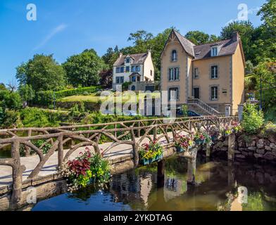 Pont Aven, Frankreich - 29. Juli 2024: Eine malerische Szene in Pont Aven mit einer rustikalen Holzbrücke über den Fluss Aven, geschmückt mit bunten Blumen, Stockfoto