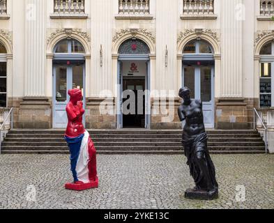 Rennes, Frankreich - 26. Juli 2024: Zwei Kopien der antiken Venus de Milo Statue, eine in Farben der französischen Flagge, die andere in Schwarz, eine Person Stockfoto