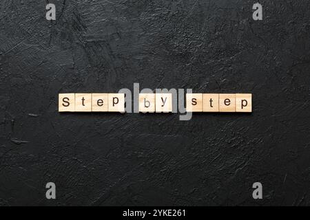 Schritt für Schritt Wort auf Holzblock geschrieben. Schritt für Schritt Text auf Tabelle, Konzept. Stockfoto