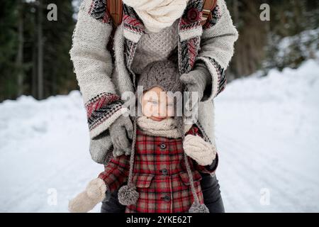 Mutter und Tochter stehen mitten in verschneiten Landschaften. Mama und Mädchen genießen Winterurlaub in den Bergen. Stockfoto