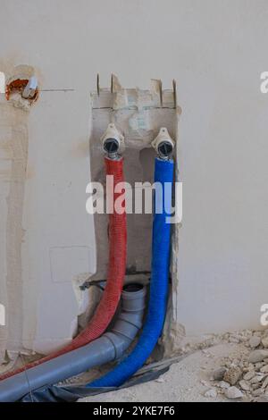 Installation von Sanitär- und Kanalrohren in einer vorbereiteten Wand während der Hausrenovierung. Konzept der Wohnungsrenovierung und Inneneinrichtung Stockfoto