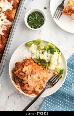 Lasagne-Roll-up auf einem Teller mit gedämpftem Gemüse Stockfoto