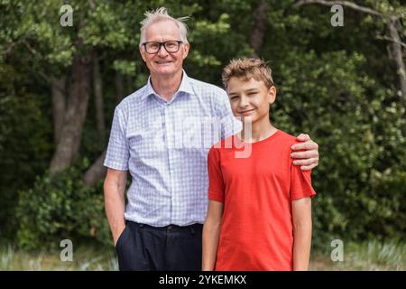 Porträt Großvater und Teenager auf Spaziergang am Strand Stockfoto