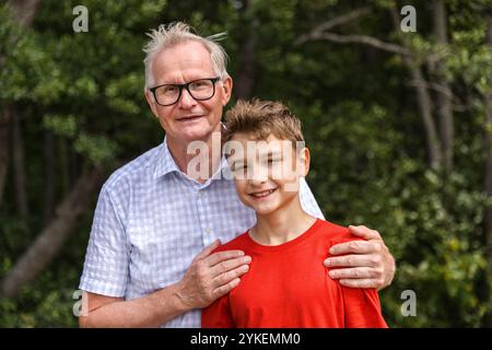 Porträt Großvater und Teenager auf Spaziergang am Strand Stockfoto