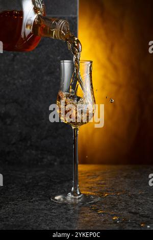 Starkes alkoholisches Getränk aus einer Flasche in ein Glas gießen. Kopierbereich. Stockfoto