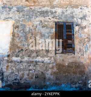 Altes grünes Holzfenster mit blauen und weißen Vorhängen auf der Insel Favignana in Trapani Sizilien Italien Stockfoto