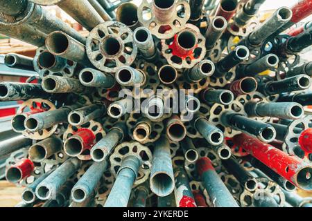 Stapel gebrauchter, verschlissener verzinkter Stahlgerüstrohre und -Rohre auf der Baustelle, selektiver Fokus Stockfoto