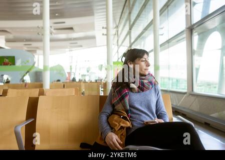 Hübsche junge Frau an einem Tor, einer modernen Flughafen warten Stockfoto