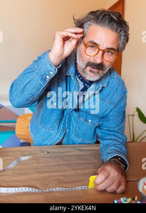 Porträt eines Mannes mittleren Alters, der zu Hause ein Muster entwirft Stockfoto