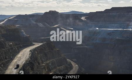 Luftaufnahme mit der riesigen Mine Rio Tinto mit ihren komplizierten Terrassen und einem einsamen Lkw, der die kurvenreichen Straßen befährt. Stockfoto