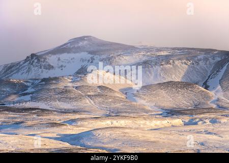 Unberührter Schnee bedeckt die Hänge des Thorsmork Valley, getaucht in das sanfte Licht der goldenen Stunde und zeigt Islands ruhige, winterliche Schönheit. Stockfoto